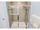 Modern shower enclosed in glass featuring light beige tile, decorative accent tiling, and adjustable shower head at 1809 Mill Creek Sw Ln, Concord, NC 28025