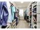 Walk-in closet with clothing racks and organized storage solutions along both sides, lit by a window at 1809 Mill Creek Sw Ln, Concord, NC 28025
