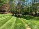 Scenic backyard with mature trees, landscaped yard, stone benches, and a tranquil water feature at 1832 Marthas Vineyard Rd, York, SC 29745