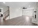 Spacious living room with a brick fireplace, modern ceiling fan, and seamlessly connected staircase at 1921 Woodridge Dr, Hickory, NC 28602
