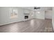 Open-concept living room with bright painted brick fireplace, lots of natural light, and hardwood flooring at 1921 Woodridge Dr, Hickory, NC 28602