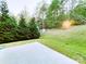 Spacious backyard featuring a patio, a gentle slope, evergreens, and sunshine at 1923 Caprington Dr, Fort Mill, SC 29707