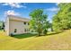 Expansive backyard with lush green grass, mature tree, and a small patio area for entertaining at 1923 Caprington Dr, Fort Mill, SC 29707