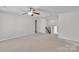 Spacious bonus room featuring plush carpeting, ceiling fan, and ample natural light, perfect for relaxation and entertainment at 1923 Caprington Dr, Fort Mill, SC 29707