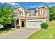 Charming two-story home featuring stone accents, solar panels, a two-car garage and a well-manicured lawn at 1923 Caprington Dr, Fort Mill, SC 29707