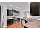 Modern kitchen featuring stainless steel appliances, granite countertops, dark cabinets, and hardwood floors at 1923 Caprington Dr, Fort Mill, SC 29707