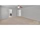 Open main bedroom with an ensuite bathroom, carpet floors, a ceiling fan, and a light color palette at 1923 Caprington Dr, Fort Mill, SC 29707