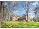 Lush backyard with mature trees, a spacious lawn, and a deck, creating a serene outdoor oasis at 25 Blenheim Ne Ct, Concord, NC 28025
