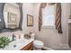 Bathroom features vanity with sink, wood cabinet, decorative mirror, and framed artwork at 25 Blenheim Ne Ct, Concord, NC 28025
