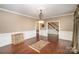 Elegant dining room featuring hardwood floors, crown molding, and classic chandelier at 25 Blenheim Ne Ct, Concord, NC 28025