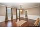 Open dining room features hardwood floors, decorative rug, two windows, and elegant chandelier at 25 Blenheim Ne Ct, Concord, NC 28025