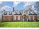 Attractive brick home with a well-manicured lawn, dormers, and a welcoming entryway at 25 Blenheim Ne Ct, Concord, NC 28025
