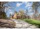 Brick home featuring a long drive way with grass on the right and a mix of trees and bushes at 25 Blenheim Ne Ct, Concord, NC 28025