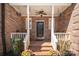 Charming front porch with brick steps, hanging planters, and a cozy swing at 25 Blenheim Ne Ct, Concord, NC 28025