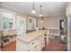 Bright kitchen with island seating, stainless appliances, and a view to the sunroom at 25 Blenheim Ne Ct, Concord, NC 28025