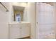Traditional bathroom with a shower curtain, white cabinets, and a large mirror reflecting a view through to another room at 2846 Snead Ne Ct, Conover, NC 28613