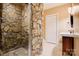 Rustic bathroom with stone shower, vanity, and toilet showcasing a unique design at 2846 Snead Ne Ct, Conover, NC 28613