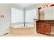 Bright bathroom features a soaking tub with tile surround and a corner window for natural light at 2846 Snead Ne Ct, Conover, NC 28613
