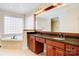 Bright bathroom features a double sink vanity with dark wood cabinetry and a relaxing soaking tub at 2846 Snead Ne Ct, Conover, NC 28613