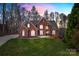 Charming brick home with a manicured lawn and mature trees, set against a picturesque sky at dusk at 2846 Snead Ne Ct, Conover, NC 28613