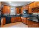 Well-lit kitchen featuring wood cabinetry, sleek black appliances, granite countertops, and stylish backsplash at 2846 Snead Ne Ct, Conover, NC 28613
