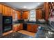A well-lit kitchen featuring a double oven, wood cabinetry, granite countertops, and a garden view from the window at 2846 Snead Ne Ct, Conover, NC 28613