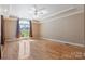 Main bedroom featuring hardwood floors, tray ceiling, and a bright window offering views of the outside at 2846 Snead Ne Ct, Conover, NC 28613