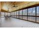 A spacious screened-in porch with a wood ceiling, ceiling fans, and a view of the wooded backyard at 2846 Snead Ne Ct, Conover, NC 28613