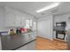 Kitchen with white cabinets, black countertops and wood-look laminate flooring at 311 S Cedar St # C, Lincolnton, NC 28092
