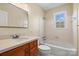 Well-lit bathroom with a single sink vanity, tiled walls, and a combined bathtub and shower at 343 Wakefield Dr # B, Charlotte, NC 28209
