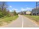 Street view with modern townhomes on a paved road amidst trees and lawns at 343 Wakefield Dr # B, Charlotte, NC 28209