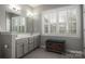 Bathroom featuring double vanity with neutral cabinets, wood look tile floors, and plantation shutters at 4225 Jasmin May Dr, Charlotte, NC 28226