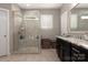Bathroom featuring a walk-in glass shower with tile surround and dark vanity with granite countertop at 4225 Jasmin May Dr, Charlotte, NC 28226