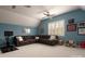 Bonus room featuring a large leather sectional sofa, neutral carpet, and multiple windows for natural light at 4225 Jasmin May Dr, Charlotte, NC 28226