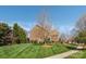 Well-manicured lawn featuring a brick home exterior, mature trees, and landscaped yard at 4225 Jasmin May Dr, Charlotte, NC 28226