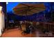 Outdoor dining area on a deck with a large umbrella, grill, and scenic view at dusk at 4232 Belle Meade Cir, Belmont, NC 28012