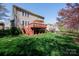 Green backyard featuring a wooden deck with patio umbrella, ideal for outdoor entertaining and relaxation at 4232 Belle Meade Cir, Belmont, NC 28012