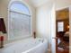 Bathroom features a large soaking tub, arched window, and an adjacent bedroom at 4232 Belle Meade Cir, Belmont, NC 28012
