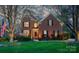 Charming two-story brick home with a well-manicured lawn, mature trees and an American flag at 4232 Belle Meade Cir, Belmont, NC 28012