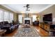 Bright living room with a fireplace, hardwood floors, leather furniture and ceiling fans at 4232 Belle Meade Cir, Belmont, NC 28012