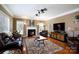 Warm living room features a fireplace, hardwood floors, leather furniture and natural light at 4232 Belle Meade Cir, Belmont, NC 28012