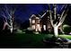 Beautifully landscaped front yard at night with illuminated trees and a charming two-story home in the background at 4232 Belle Meade Cir, Belmont, NC 28012