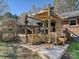Well-maintained backyard with a wooden deck, stairs, and a patio area at 4522 Chuckwood Dr, Mint Hill, NC 28227