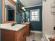 A traditional bathroom featuring beadboard walls, double sinks, and a shower-tub combo with a shower curtain at 4522 Chuckwood Dr, Mint Hill, NC 28227