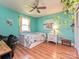 Bright bedroom with a ceiling fan, light wood floors, a bed with drawers, and a white bedside table at 4522 Chuckwood Dr, Mint Hill, NC 28227