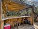 Outdoor bar area with a wood pergola and stool seating for entertaining guests at 4522 Chuckwood Dr, Mint Hill, NC 28227