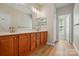 Bathroom featuring double sinks with wood cabinets, and a window overlooking the yard at 4818 Grier Farm Ln, Charlotte, NC 28270