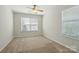 Bright bedroom with carpet, ceiling fan, and two windows allowing ample sunlight at 4818 Grier Farm Ln, Charlotte, NC 28270
