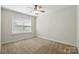 Bedroom featuring carpet, neutral walls, a window overlooking the yard, and a ceiling fan at 4818 Grier Farm Ln, Charlotte, NC 28270
