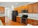 Well-lit kitchen features wood floors, stainless appliances, and wooden cabinetry at 4818 Grier Farm Ln, Charlotte, NC 28270